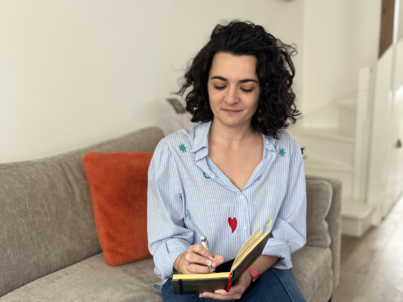 Charline Gueguen, fondatrice d'Easy Organizing, assise dans un salon et prenant des notes dans un carnet. Étape 1 : Le diagnostic - L'état des lieux sans honte.