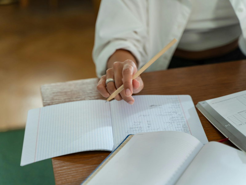 Gros plan sur une personne rédigeant un plan d'action manuscrit dans un cahier. Étape 2 : Le plan d'action - Un cap précis, zéro impro.